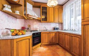a kitchen with wooden cabinets and a stove top oven at Apartments SKULIN in Novi Vinodolski