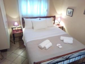 une chambre avec un grand lit avec deux serviettes dessus dans l'établissement Voula Home, à Marathi 9 autres photos