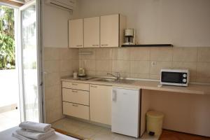 a small kitchen with a sink and a microwave at Guest House Mićin in Vodice