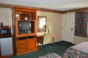 a hotel room with a television and a desk with a computer at Gateway Inn Fairfield in Fairfield