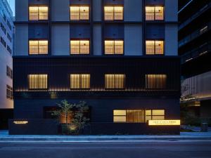 a tall black building with lights in the windows at Mitsui Garden Hotel Kyoto Station in Kyoto