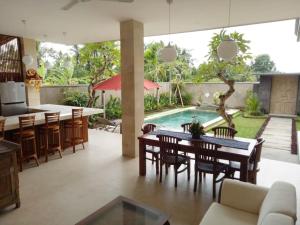 una cucina e una sala da pranzo con tavolo e piscina di Villa Tenang ad Ubud