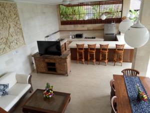 un soggiorno con divano e tavolo e una cucina di Villa Tenang ad Ubud
