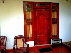 a red door in a room with two chairs at Ella Sunrise in Ella