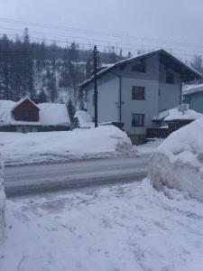 什切爾克的住宿－Domek w Szczyrku，积雪覆盖的街道,有建筑和房屋