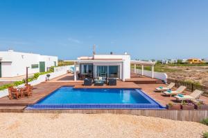 a backyard with a swimming pool and a house at Villa Marta in Es Mercadal