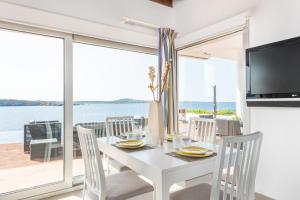 a white dining room with a white table and chairs at Villa Marta in Es Mercadal