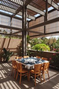 a patio with a table and chairs under a pergola at Sotavento Beach Club in Costa Calma