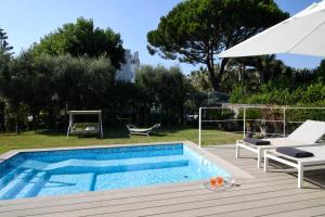 a swimming pool with a chair and an umbrella at Villa Massa Residence in Sant'Agnello