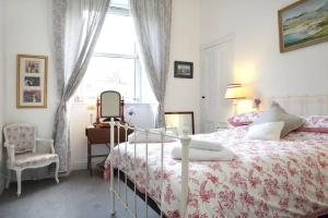 a bedroom with a bed and a chair and a window at 5 star beautiful & vintage, spacious apt in chic location! in Edinburgh