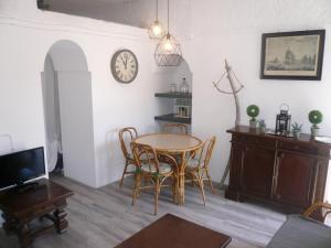 uma sala de jantar com mesa e cadeiras e um relógio em Appartamento Stellamares em Marciana