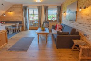 ein Wohnzimmer mit einem Sofa und einem Tisch in der Unterkunft Ferienhof AllgäuMax in Füssen