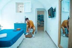 a man sitting on a bed in a room at Alaka Holiday Home in Gallipoli