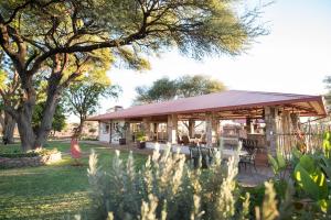 a pavilion with tables and chairs in a park at Dornhuegel Guest Farm in Groutfontein