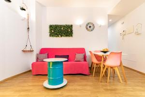 sala de estar con sofá rojo y mesa en Apartamentos Momas La Casa De Mamá, en Málaga