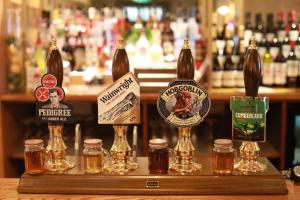 a counter with bottles of beer and jars of honey at Green Lodge, Wirral by Marston's Inns in Hoylake