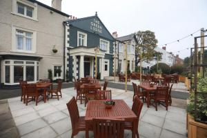 a patio with tables and chairs in front of a restaurant at Green Lodge, Wirral by Marston's Inns in Hoylake