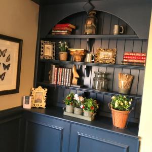 a shelf with potted plants and books on it at Green Lodge, Wirral by Marston's Inns in Hoylake