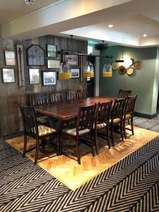 a dining room with a wooden table and chairs at Green Lodge, Wirral by Marston's Inns in Hoylake