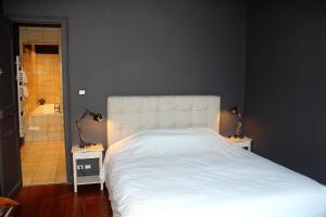 a bedroom with a large white bed and a bathroom at Burdigala Homes - Appart Clemenceau in Bordeaux