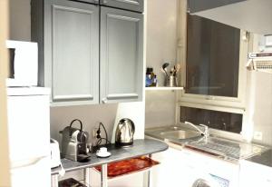 een keuken met witte kasten en een spoelbak bij Burdigala Homes - Appart Clemenceau in Bordeaux +3 foto's