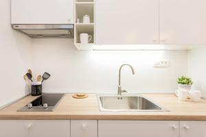 a kitchen with a sink and white cabinets at City Center Apartments in Zagreb