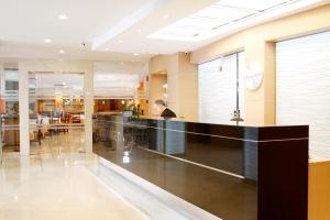 a man sitting at a counter in a lobby at Hotel Metropolitan Playa 3 Sup in Playa de Palma