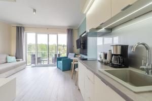 a kitchen with a sink and a living room at Apartment Flamingo 27 by Renters in Międzyzdroje