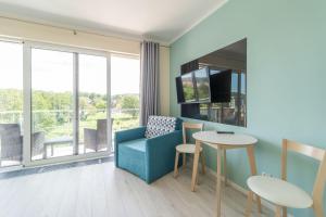 a living room with a blue couch and a table at Apartment Flamingo 27 by Renters in Międzyzdroje