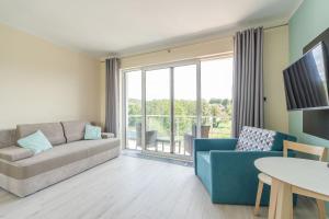 Televízia a/alebo spoločenská miestnosť v ubytovaní Apartment Flamingo 27 by Noclegi Renters