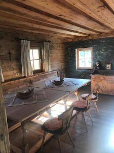 a dining room with a large wooden table and chairs at Grossummerstall in Mittersill