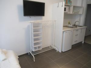 een woonkamer met een tv aan de muur en een keuken bij Apartamento 1ª linea Las Canteras -vista mar con terraza y wifi 308 in Las Palmas de Gran Canaria