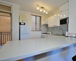 a kitchen with white cabinets and a white counter top at Cappuccino Delight - 1 bedroom central Fremantle apartment in Fremantle