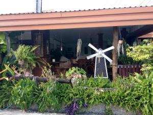 a windmill in the window of a house with plants at Pruksa Garden Hotel in Phu Wiang