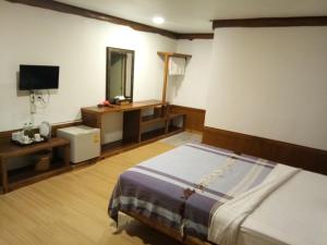 a bedroom with a bed and a television in it at Pruksa Garden Hotel in Phu Wiang