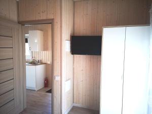 a room with wood paneled walls and a kitchen at Delta Plius in Šventoji +6 photos
