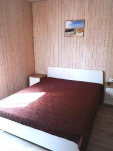 um quarto com uma cama com um cobertor vermelho em Delta Plius em Šventoji