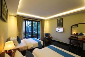 a hotel room with two beds and a window at Chheng Residence in Siem Reap