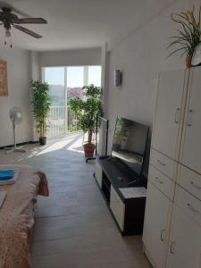 a bedroom with a bed and a flat screen tv at Studio El Faro in Torrox Costa