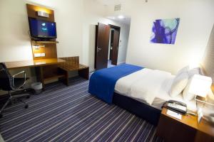 a hotel room with a bed and a desk and a computer at Holiday Bahrain Hotel in Manama