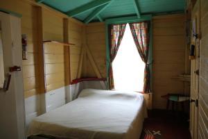 a small room with a bed and a window at Finjam Cottage in Port Antonio