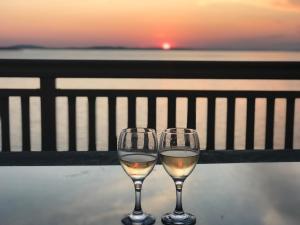 two glasses of white wine sitting on top of a table at Sunset-Oase 4 in Prizna