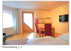 a room with a table and a kitchen with a dining room at Ferienwohnung Wanderlust in Klingenmünster