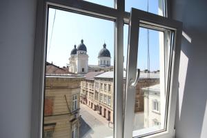 an open window with a view of a building at Romantic Panorama Krakivska street in Lviv