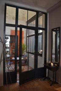 ボルドーにあるBurdigala Homes - Appart du Jardin Publicのテーブルを望む大きなガラスドアが備わる客室です。