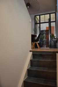 Una escalera que conduce a una habitación con ventana y silla en Burdigala Homes - Appart du Jardin Public, en Burdeos