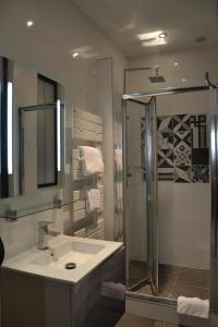 a bathroom with a glass shower and a sink at Burdigala Homes - Appart du Jardin Public in Bordeaux