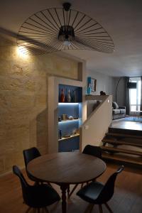 Un comedor con mesa y sillas de madera. en Burdigala Homes - Appart du Jardin Public, en Burdeos
