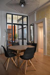 a dining room with a wooden table and chairs at Burdigala Homes - Appart du Jardin Public in Bordeaux