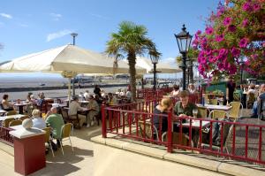 un gruppo di persone seduti ai tavoli vicino alla spiaggia di Old Colonial, Weston-Super-Mare by Marston's Inns a Weston-super-Mare